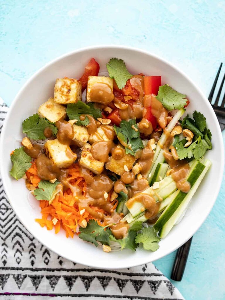 bowl of noodles with peanut butter sauce and tofu chunks